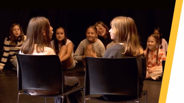 Kinderen tijdens creatief zomerkamp in Antwerpen spelen improvisatietheater en werken aan expressie
